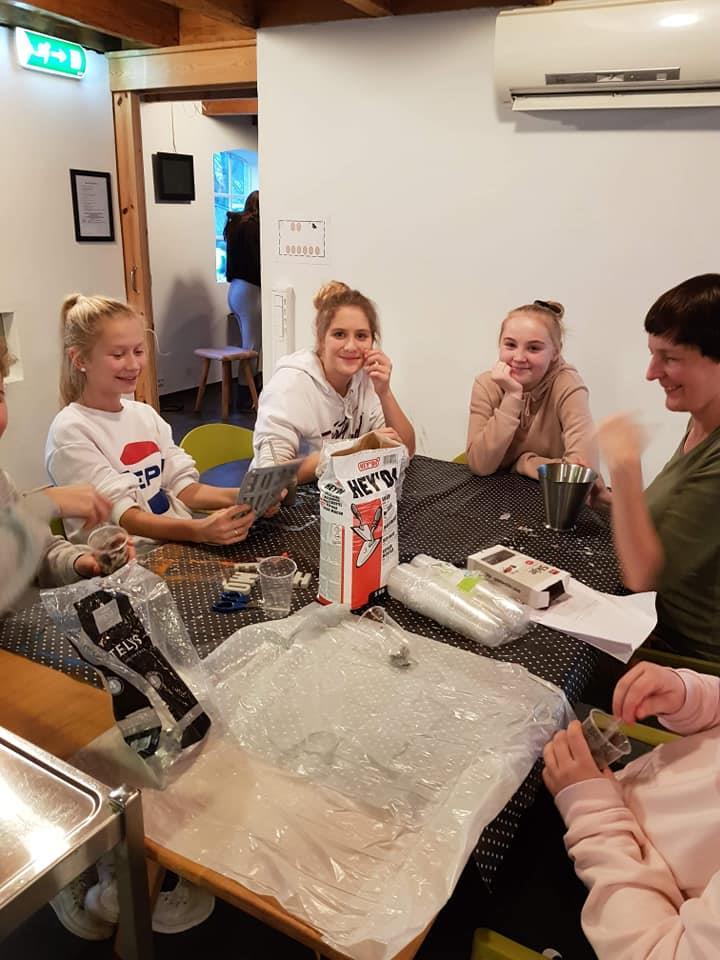 Tre jenter som sitter ved bordet og jobber med leire. Foto - Klikk for stort bilete