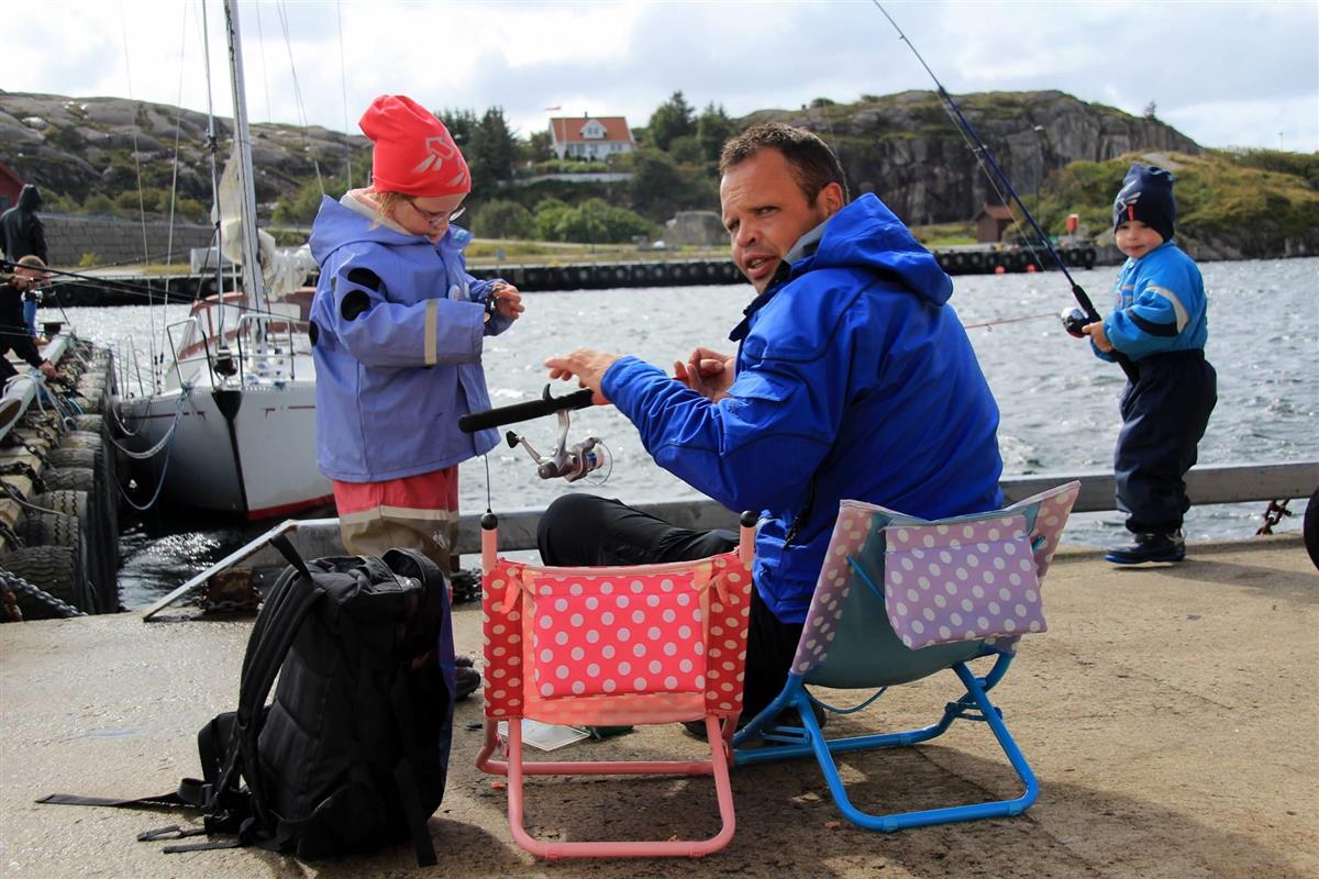 Familie fisker på kaien i Sirevåg - Klikk for stort bilete