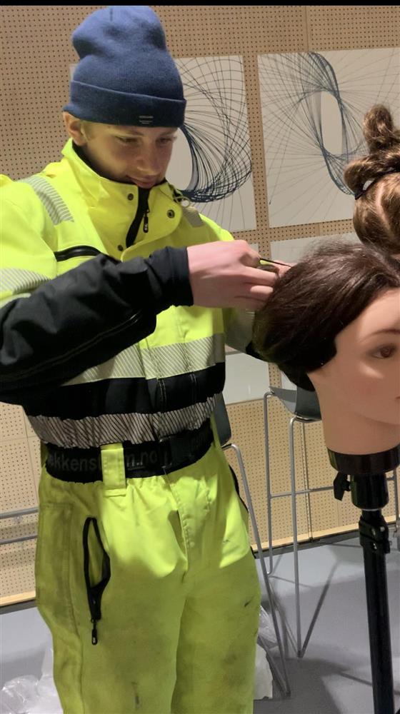 Gutt prøver seg som frisør på hårdukke. Foto - Klikk for stort bilete